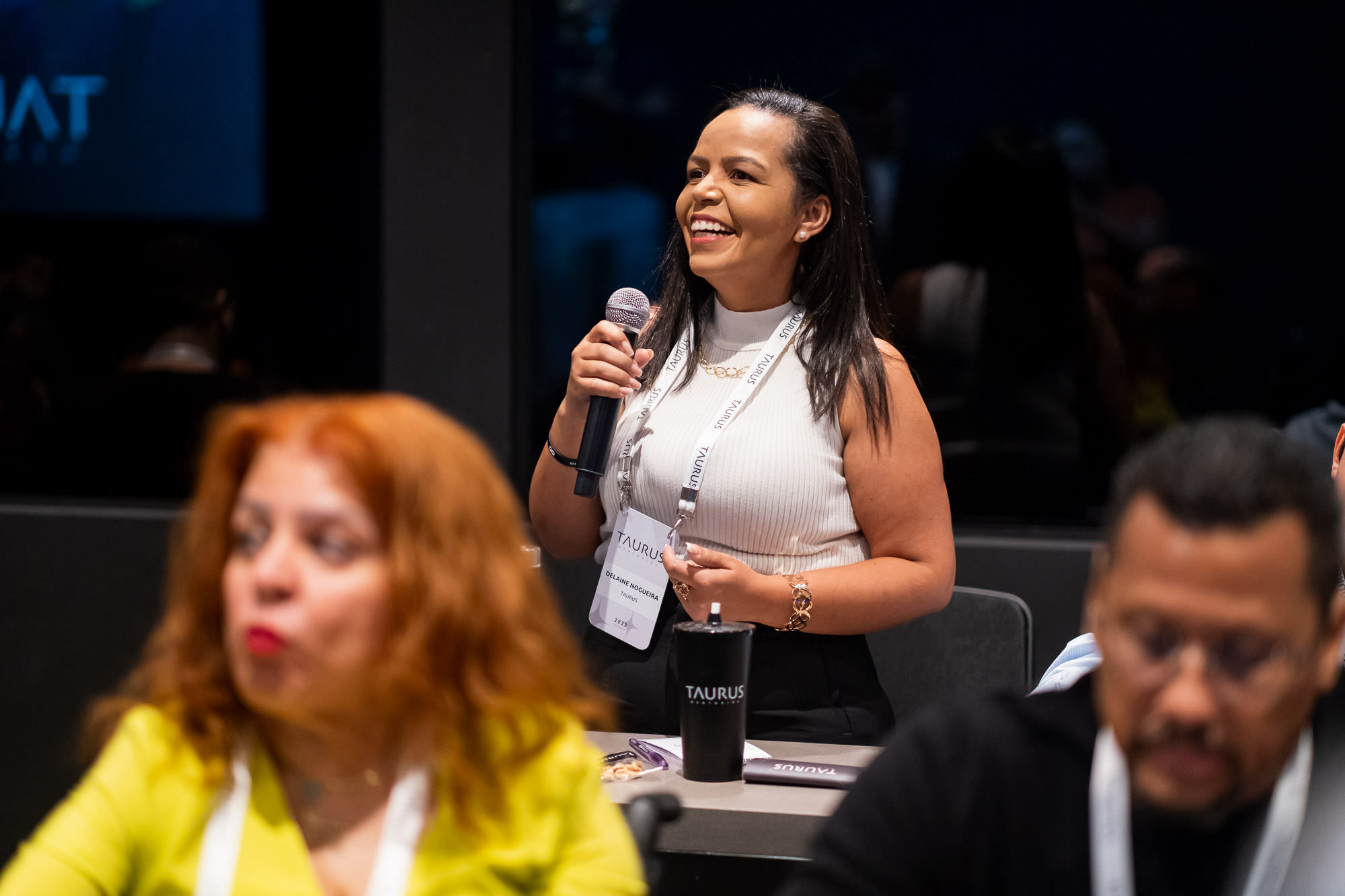 Delaine Nogueira falando ao microfone em um evento
